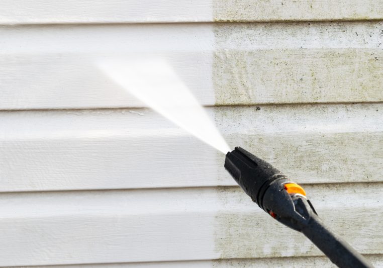 Cleaning service washing building facade with pressure water. Cleaning dirty wall with high pressure water jet. Power washing the wall. Cleaning the facade of the house. Before and after washing